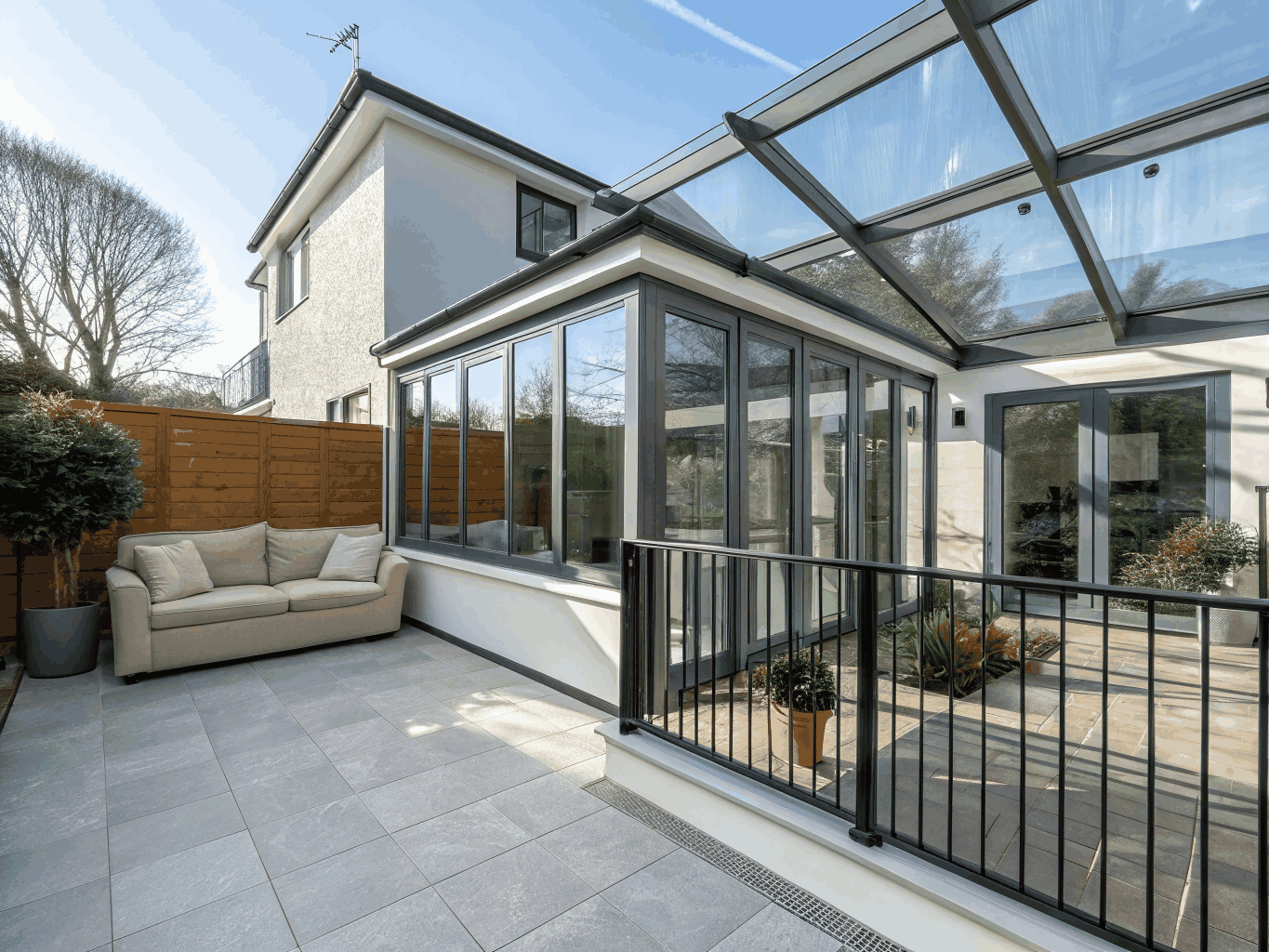 Four-season sunroom home addition in Powder Springs featuring cathedral wood ceilings, expansive black-frame windows, and natural woodland views