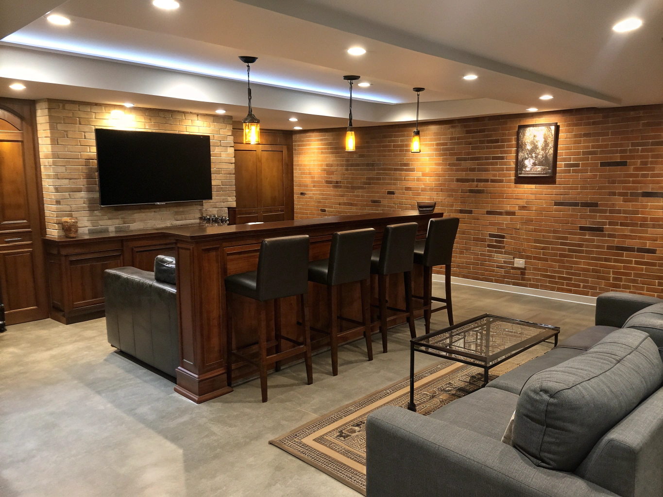 Finished basement remodel and entertainment lounge in Georgia featuring custom quartz wet bar, beverage refrigeration, and recessed architectural lighting